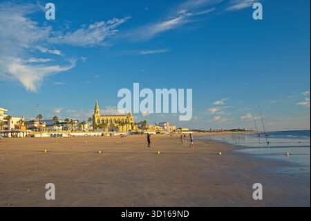 Plage de Regla avec église et phare à Chipiona dans la lumière chaude du soir Banque D'Images
