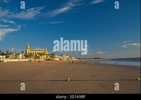 Plage de Regla avec église et phare à Chipiona dans la lumière chaude du soir Banque D'Images
