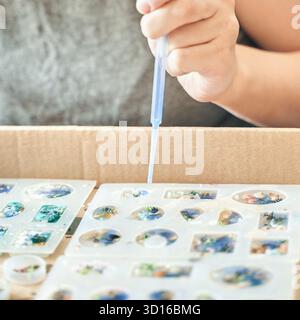 Gros plan de l'artisanat avec des moules en résine jeune femme adulte créant à la main des cadres Banque D'Images