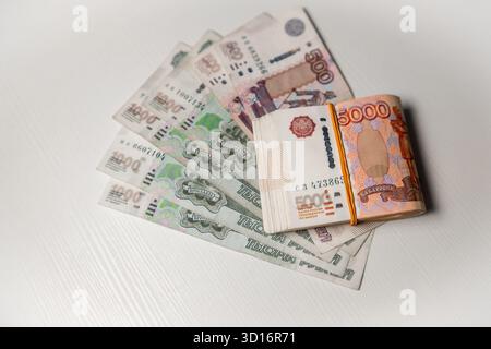 Plusieurs billets de banque russes de différentes coupures placés soigneusement sur une surface de couleur claire, mettant en évidence le design et les détails de la monnaie. Banque D'Images