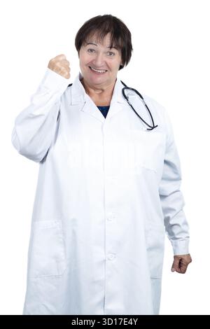Médecin senior portant une blouse de laboratoire et un stéthoscope, souriant et serrant son poing dans un geste de triomphe, représentant la réussite Banque D'Images