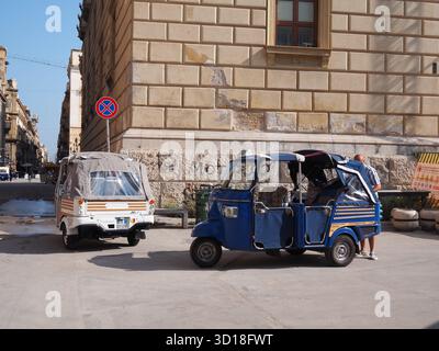 Tuk-tuks colorés garés à côté d'un bâtiment historique dans le centre de Palerme par une journée ensoleillée Banque D'Images