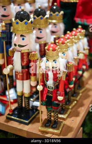 Soldats casse-noix classiques en rouge, vert et or alignés sur une étagère - idéal pour les décors nostalgiques des fêtes et les campagnes traditionnelles de Noël. Banque D'Images