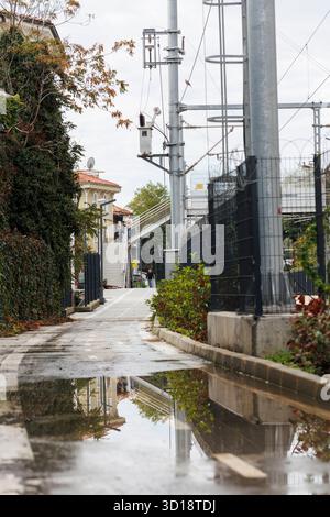 un puddlu sur la piste cyclable et reflet des maisons sur elle près de la ligne de tramway à istanbul Banque D'Images