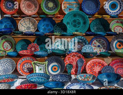 Sélection d'assiettes et de bols en céramique grecque traditionnelle peints à la main de couleurs vives exposées dans une boutique de cadeaux touristique grecque traditionnelle Banque D'Images