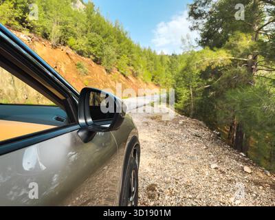 Gros plan d'une voiture garée sur une route de montagne de gravier Banque D'Images