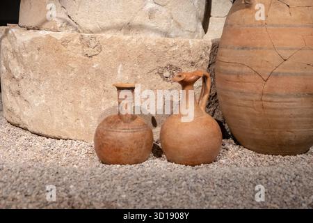 Collection de poteries anciennes de formes et d'usages différents, présentées sur une surface de gravier, dans un contexte archéologique Banque D'Images