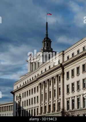 Sofia, Bulgarie - 13 novembre 2017 : le bâtiment de l'Assemblée nationale bulgare sous un ciel dramatique avec le drapeau national flottant au sommet de sa flèche. Banque D'Images