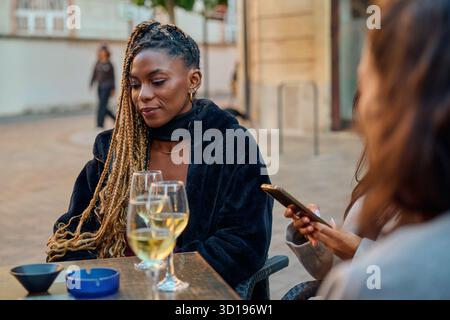 Femme appréciant le vin blanc avec un ami dans toulouse café Banque D'Images