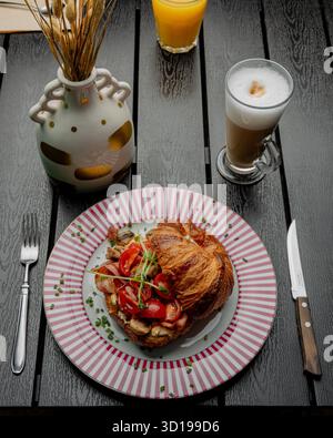 Croissant avec remplissage sur une belle assiette isolée Banque D'Images