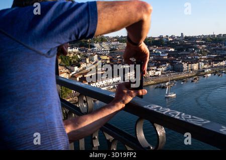 Vue d'une personne prenant une photo du paysage urbain de Porto depuis le pont Dom Luis I sur le fleuve Douro, au nord du Portugal, le 8 mai 2022. Le Banque D'Images