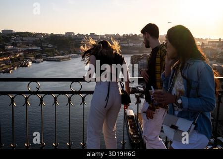 Vue d'un groupe de personnes admirant le coucher de soleil sur le fleuve Douro à Porto, au nord du Portugal, le 8 mai 2022. La scène capture l'atmosphère sereine Banque D'Images