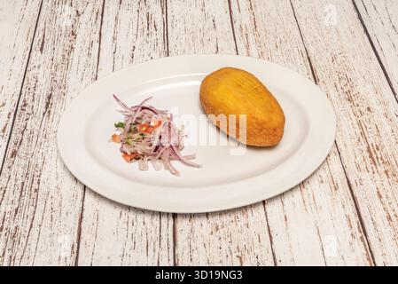 Pommes de terre péruviennes farcies gourmandes avec purée de pommes de terre jaunes farcies de steak ​​sirloin finement tranché et d'olives noires Banque D'Images