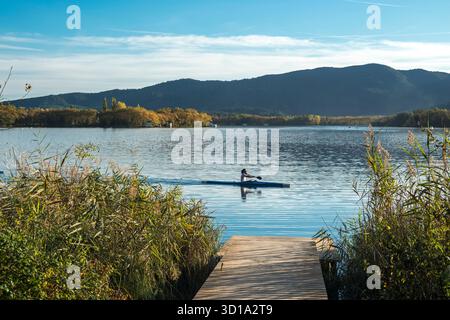 HOMME EN KAYAK PASSANT JETÉE EN BOIS LAC DE BANYOLES PLA DE L’ESTANY GIRONA PROVINCE CATALOGNE ESPAGNE Banque D'Images
