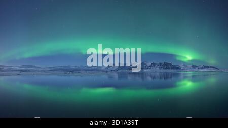 Vue sur les aurores boréales éthérées dansant au-dessus des eaux tranquilles, reflétant le spectacle céleste dans un spectacle à couper le souffle, Jokulsarlon, Sveitarfélagið Hornafjörður, Islande. Banque D'Images