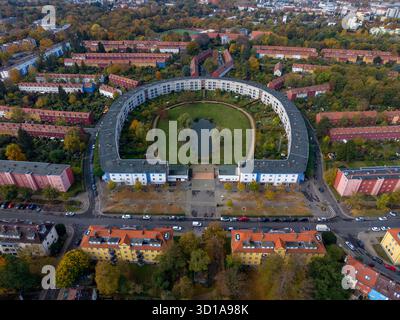 Vue aérienne du domaine Hufeisensiedlung en forme de fer à cheval embrasse un cœur verdoyant, une oasis moderne au milieu de l'étreinte dorée de l'automne, Berlin, Berlin, Allemagne. Banque D'Images