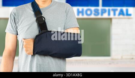 Gros plan d'un homme caucasien méconnaissable portant une écharpe de bras avec fond d'hôpital Banque D'Images