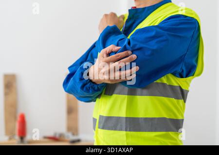 Douleurs aux mains, à la personne et au coude avec blessure de construction, accident sur le chantier ou entorse avec agonie à l'intérieur. Douleur articulaire, contractant avec tension musculaire du bras Banque D'Images