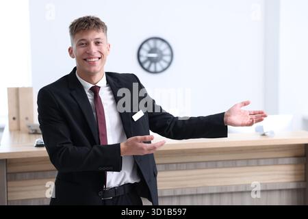 Réceptionniste en uniforme accueillant près de la réception à l'intérieur Banque D'Images