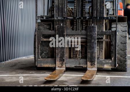 Vue avant du chariot élévateur avec fourches de levage métalliques visibles et grands pneus en caoutchouc montrant les détails de la machine industrielle, le système de levage hydraulique et durab Banque D'Images