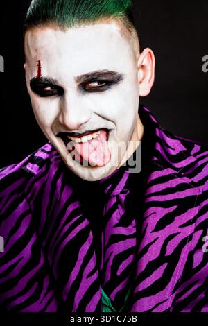 Un clown effrayant pose en studio sur le fond isolé. Halloween, Cosplay et Movie concept. Banque D'Images