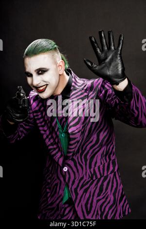 Un clown effrayant pose en studio sur le fond isolé. Halloween, Cosplay et Movie concept. Banque D'Images