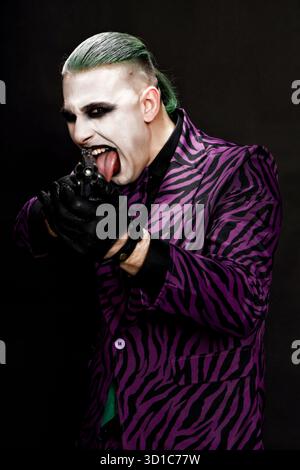 Un clown effrayant pose en studio sur le fond isolé. Halloween, Cosplay et Movie concept. Banque D'Images
