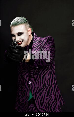 Un clown effrayant pose en studio sur le fond isolé. Halloween, Cosplay et Movie concept. Banque D'Images