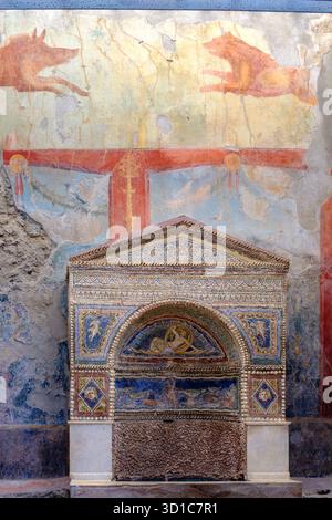 Maison de l'ours blessé, Casa dell'Orso Ferito, fresques murales de sanglier et de chien au-dessus de la fontaine de nymphée ornée de mosaïques coquillages, Pompéi, Italie Banque D'Images