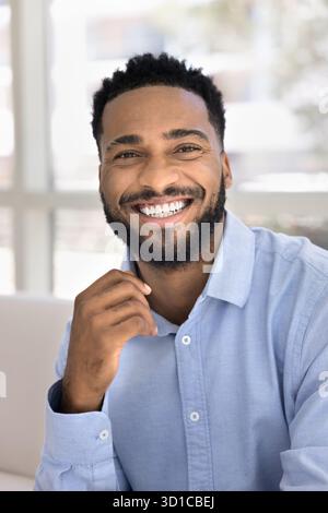 Homme africain avec une apparence attrayante et une humeur optimiste posant à l'intérieur Banque D'Images