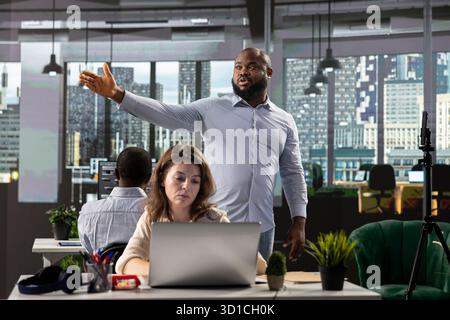 Divers professionnels collaborant à la planification et à l'analyse des affaires, examinant les données visuelles et les projections pour soutenir la stratégie et le progrès au sein de l'entreprise multinationale. Briefing. Banque D'Images