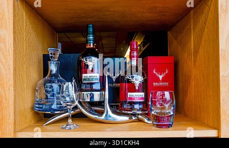 INVERNESS, ÉCOSSE – 21 août 2025 : une exposition de bouteilles de whisky écossais de qualité supérieure et de verrerie de la distillerie Dalmore, avec le célèbre cerf lo Banque D'Images