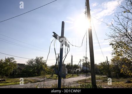 Une croix se dresse dans une rue du village de première ligne de Malokaterynivka, région de Zaporizhzhia, Ukraine, le 23 octobre 2025. La colonie, située à huit kilomètres de la ligne de front, a vu 80% de ses habitants fuir en raison des bombardements russes constants (photo de Dmytro Smolienko/Ukrinform) Banque D'Images