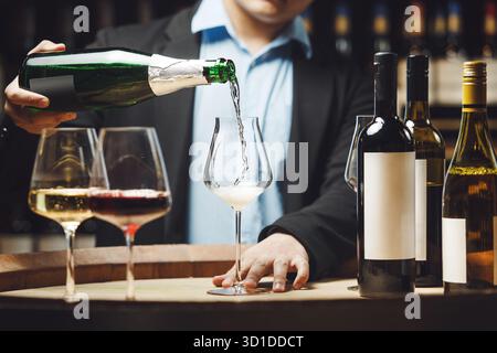 Sommelier versant du champagne dans un verre dans une cave Banque D'Images