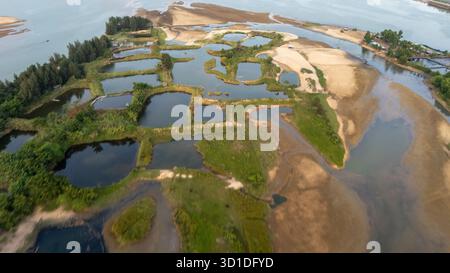 Vue aérienne des étangs aquacoles et du delta du fleuve, Vietnam—zones humides, fermes piscicoles, chenaux sinueux, bancs de sable et végétation luxuriante Banque D'Images