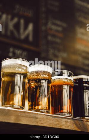 Quatre bières distinctes présentées dans les verres sur le comptoir du bar Banque D'Images