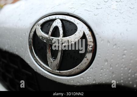 Emblème Toyota chromé avec des gouttes de pluie sur une surface de voiture argentée, gros plan après la pluie. Belgrade (Serbie) - 25 octobre 2025. Banque D'Images