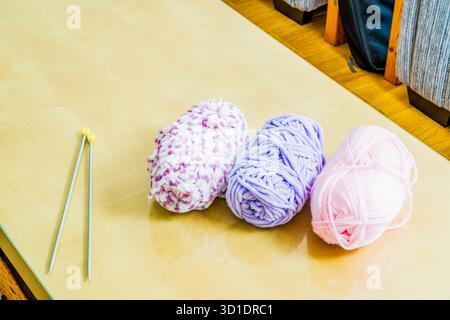 Boules colorées de laine et quelques aiguilles à tricoter, passe-temps ou concept d'artisanat Banque D'Images