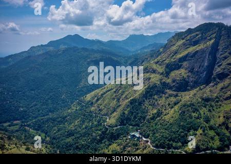 Vue aérienne des collines verdoyantes et des vallées, avec des routes sinueuses serpentant à travers le paysage sous un ciel partiellement nuageux, Ella, province d'UVA, Sri Lanka Banque D'Images