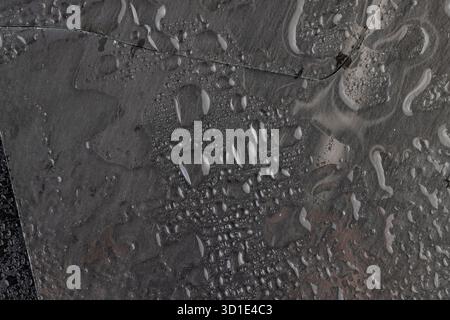 vieux verre humide cassé repose sur une planche d'ardoise avec une texture inégale, des morceaux de verre transparent cassé utilisés dans la construction recouverts de gouttelettes d'eau Banque D'Images