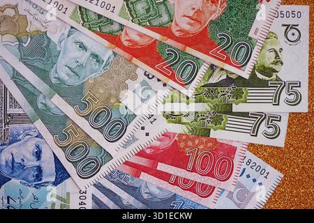 Pakistan roupies billets de banque sur fond jaune doré. Les factures d'argent pakistanaises actuelles sont sur la table en gros montant. Le concept d'affaires et d'investissement au Pakistan Banque D'Images