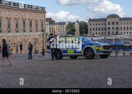 Stockholm, Suède - 08.05.2025 : deux policiers avec des fusils et une voiture de police à Gamla Stan, Stockholm, Suède Banque D'Images