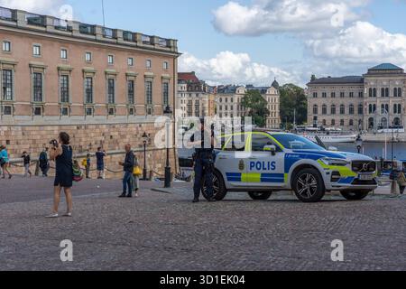 Stockholm, Suède - 08.05.2025 : deux policiers avec des fusils et une voiture de police à Gamla Stan, Stockholm, Suède Banque D'Images
