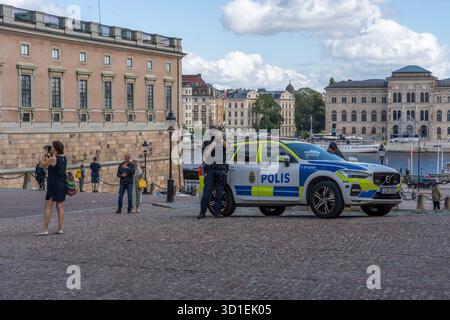 Stockholm, Suède - 08.05.2025 : deux policiers avec des fusils et une voiture de police à Gamla Stan, Stockholm, Suède Banque D'Images