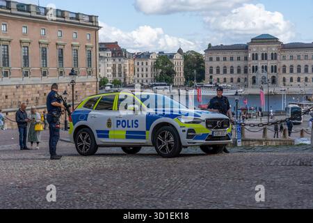 Stockholm, Suède - 08.05.2025 : deux policiers avec des fusils et une voiture de police à Gamla Stan, Stockholm, Suède Banque D'Images
