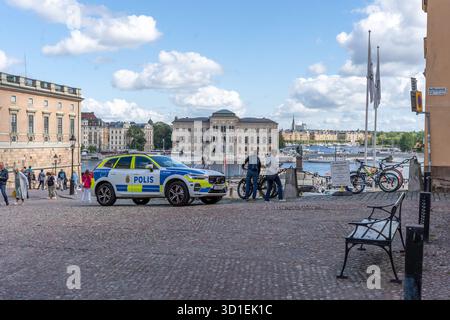 Stockholm, Suède - 08.05.2025 : deux policiers avec des fusils et une voiture de police à Gamla Stan, Stockholm, Suède Banque D'Images