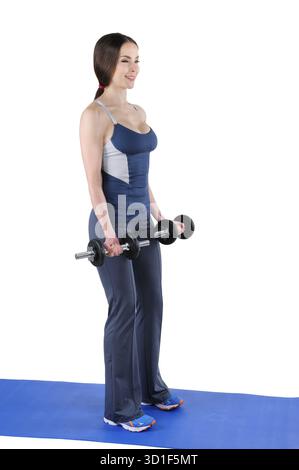 Jeune femme instructeur de fitness montre la position de départ de la boucle de biceps haltère debout, isolé sur blanc Banque D'Images