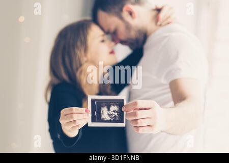 Couple enceinte tenant dans les mains échographie de leur bébé || modèle libéré Banque D'Images