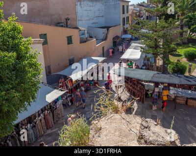 Alcudia Market, Majorque, rue animée dans une ville pittoresque bordée de boutiques et de cafés en plein air, avec des gens se promenant et profitant de la journée ensoleillée, Major Banque D'Images