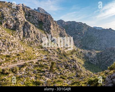 Route serpentine à sa Calobra, Majorque, route de montagne sinueuse serpente à travers un terrain accidenté et rocheux avec une végétation verte, sur fond de t Banque D'Images